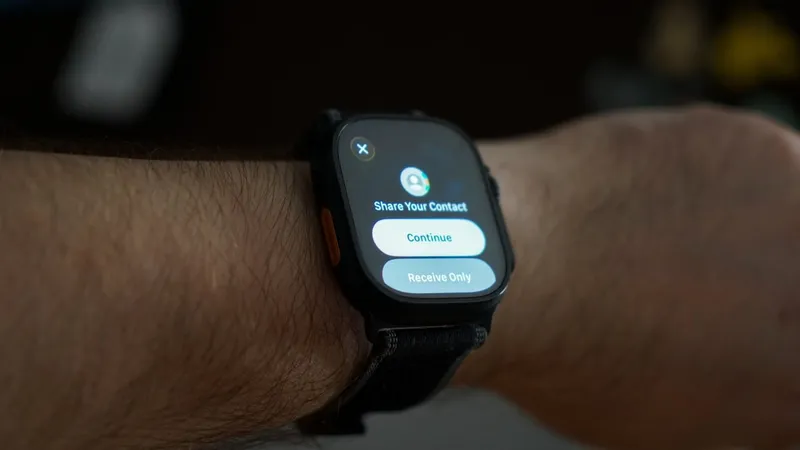 Smartwatch on a person's wrist displaying a screen with options to share contact information, featuring buttons labeled Continue and Receive Only