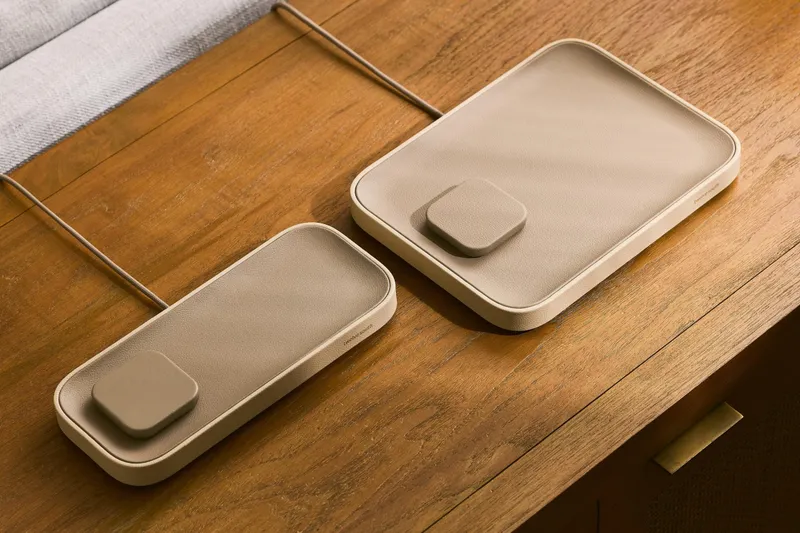 Two versions of the Twelve South Valet charging tray sitting side by side on a wooden table.