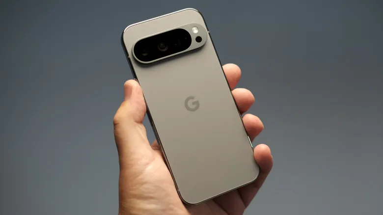 The Google Pixel 9 Pro being held against a gray background