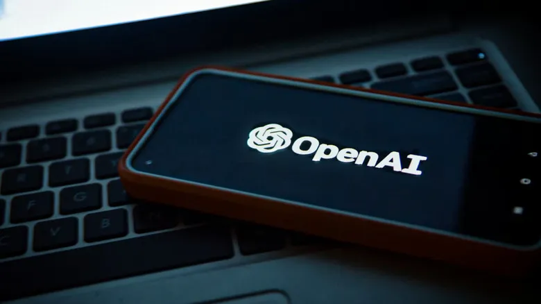 A smartphone with a logo on top of a laptop.