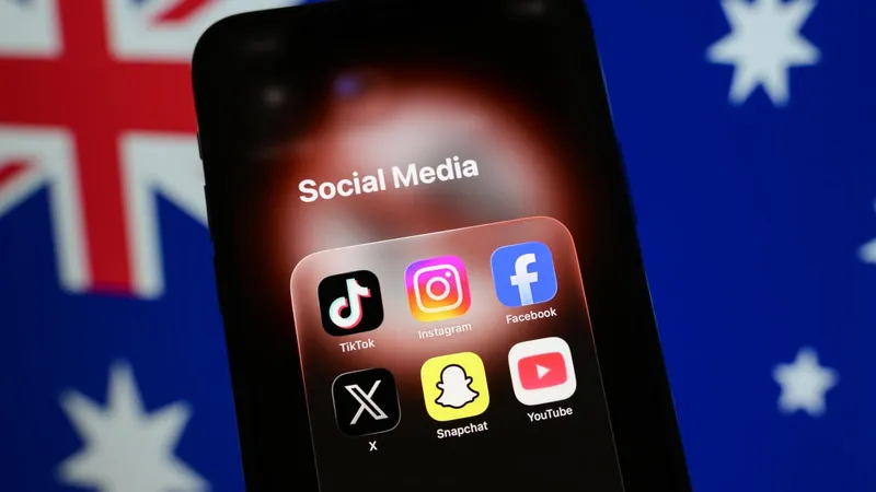 A smartphone displays a folder of social media applications, including TikTok, Instagram, Facebook, X, Snapchat, and YouTube