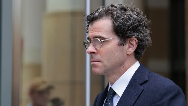 Instagram head Adam Mosseri in a suit leaving the courthouse.